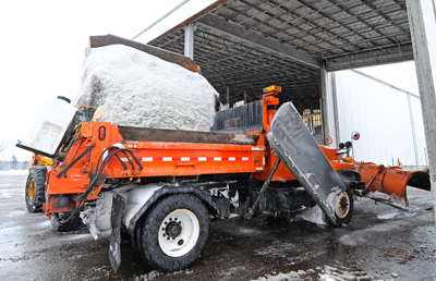 Photo of a front end loader dumping salt into a truck. 